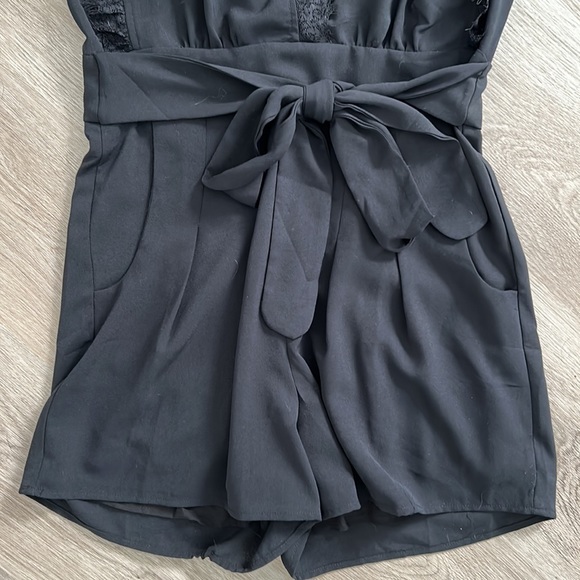 Black pleated front romper with lace trim sleeves and neck line - Picture 3 of 10
